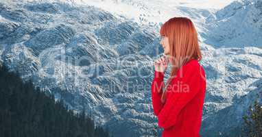 Side view of redhead woman against snowcapped mountains