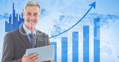 Businessman holding tablet PC against graphs