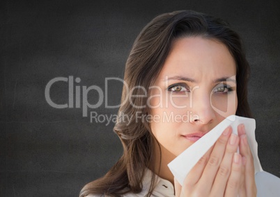 Close up of woman with tissue against grey wall