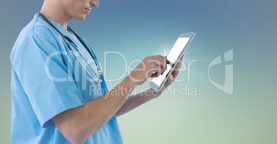 Doctor mid section touching tablet against blue green background