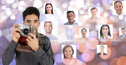 Confident photographer holding camera against flying business portraits