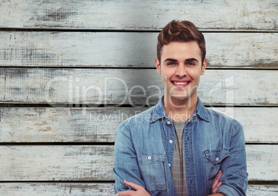 Handsome man smiling against wooden wall