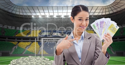Smiling businesswoman showing money at stadium representing corruption