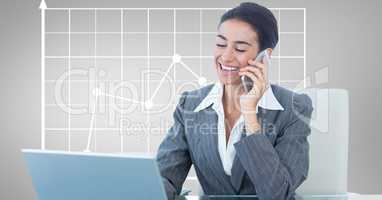 Happy businesswoman using laptop and mobile phone against graph