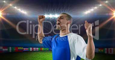 Soccer player with arms raised celebrating victory