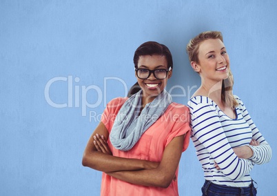 Portrait of happy businesswomen standing arms crossed against blue background