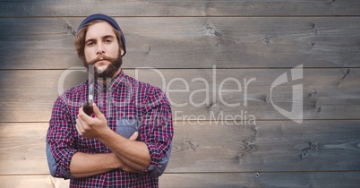 Portrait of man holding pipe against wooden background