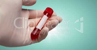 Gloved hand with red container against aqua background