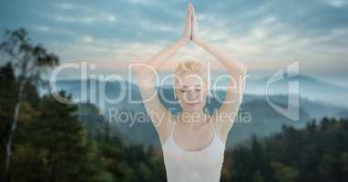 Double exposure woman meditating against mountains