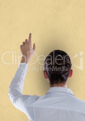 Rear view of businesswoman pointing on beige background