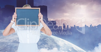 Businesswoman holding slate in front of face against globe