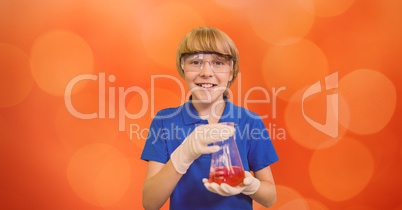 Portrait of smiling boy holding chemical flask over bokeh
