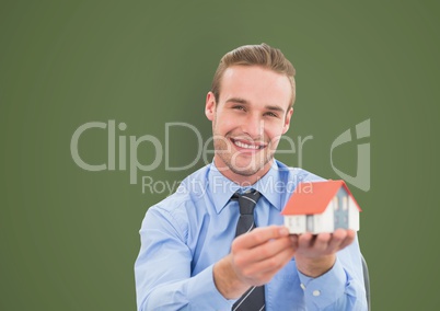 Portrait of happy businessman holding model house