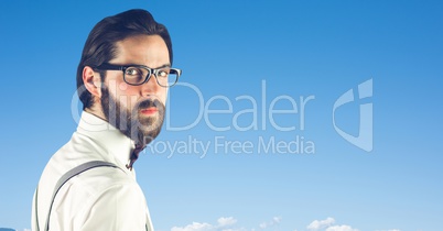 Hipster wearing eyeglasses against blue sky