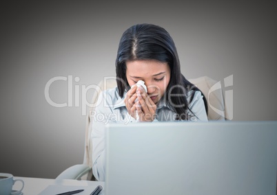 Woman crying at desk against grey background