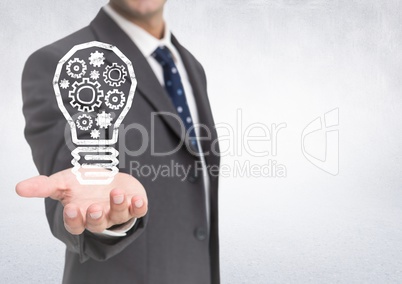 Business man hand out with lightbulb doodle against white wall