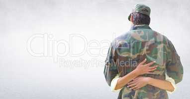 Back of soldier hugging against white wall