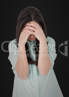 Woman with hands on face against black background