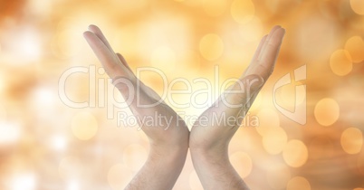 Close-up of hands against glowing bokeh