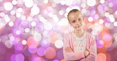 Little girl standing with arms crossed over bokeh