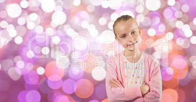 Little girl standing with arms crossed over bokeh