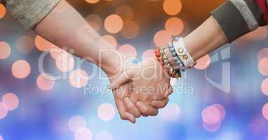Couple holding hands over bokeh
