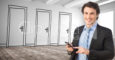 Smiling businessman using smart phone against drawn doors