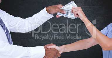 Business people shaking hands while holding money representing corruption concept