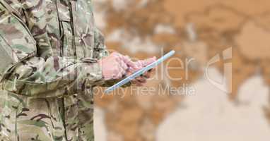Soldier mid section with tablet against blurry brown map