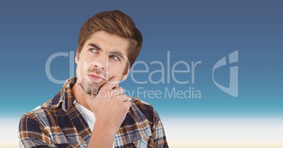 Thought male hipster with hand on chin against sky
