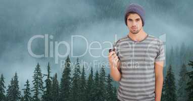 Hipster holding smoking pipe against fog covering forest