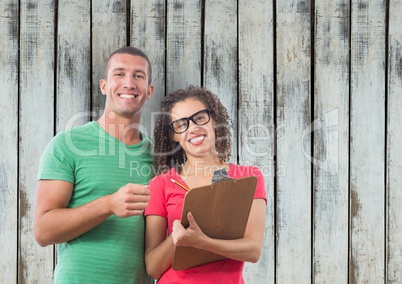 Casual business people with clipboard against wooden wall