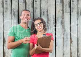 Casual business people with clipboard against wooden wall