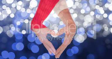 Close-up of hands making heart shape over blur background