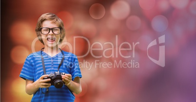 Little boy holding camera while laughing