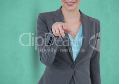 Midsection of smiling businesswoman pointing over green background