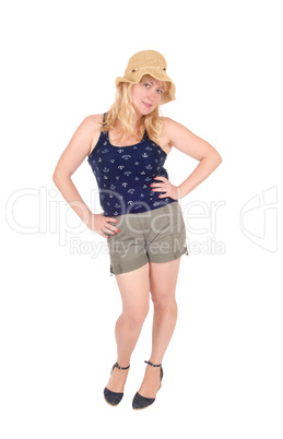 Woman standing in shorts and straw hat.