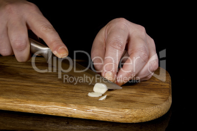 Woman chopping garlic with a knife