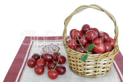 Basket with cherries on the napkin on a white background.