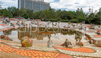 A small pond , whose banks are decorated with sculptural images