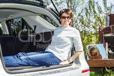 Woman sitting in trunk of car