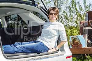 Woman sitting in trunk of car