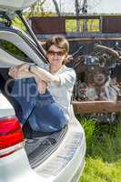 Woman sitting in trunk of car