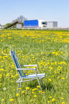 Abandoned garden chair in flower meadow