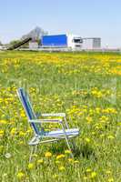 Abandoned garden chair in flower meadow