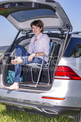 Woman sitting in trunk of car