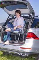 Woman sitting in trunk of car