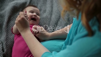 Mother massaging and doing gymnastic to her kid