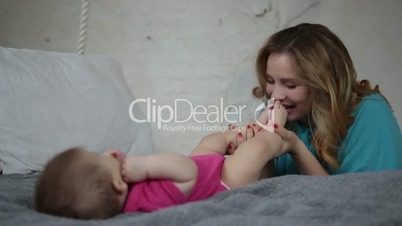 Beautiful mother kissing newborn baby's feet