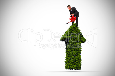 Composite image of businessman watering with red can